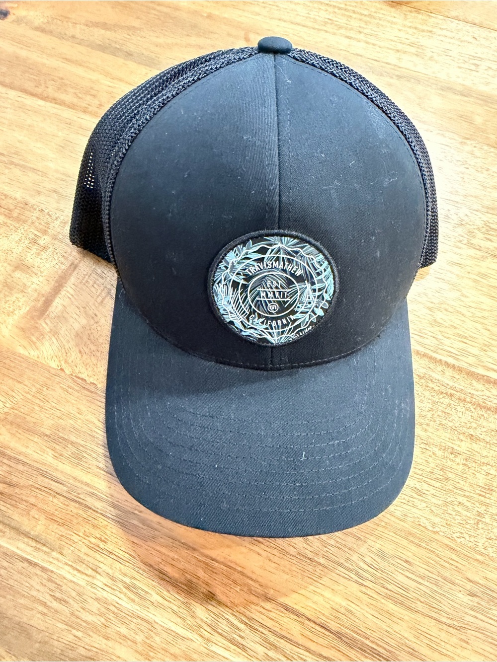 NWOT Travis Mathew Black Mesh Back Trucker Hat with Teal Patch